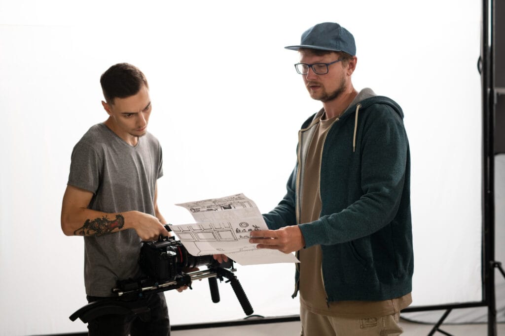 A Field Producer sharing logistical information with videographer on a set.